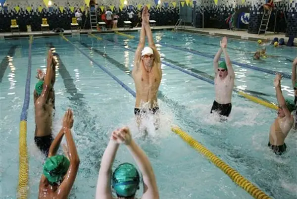 Michael Phelps showing some young swimmers some tricks.